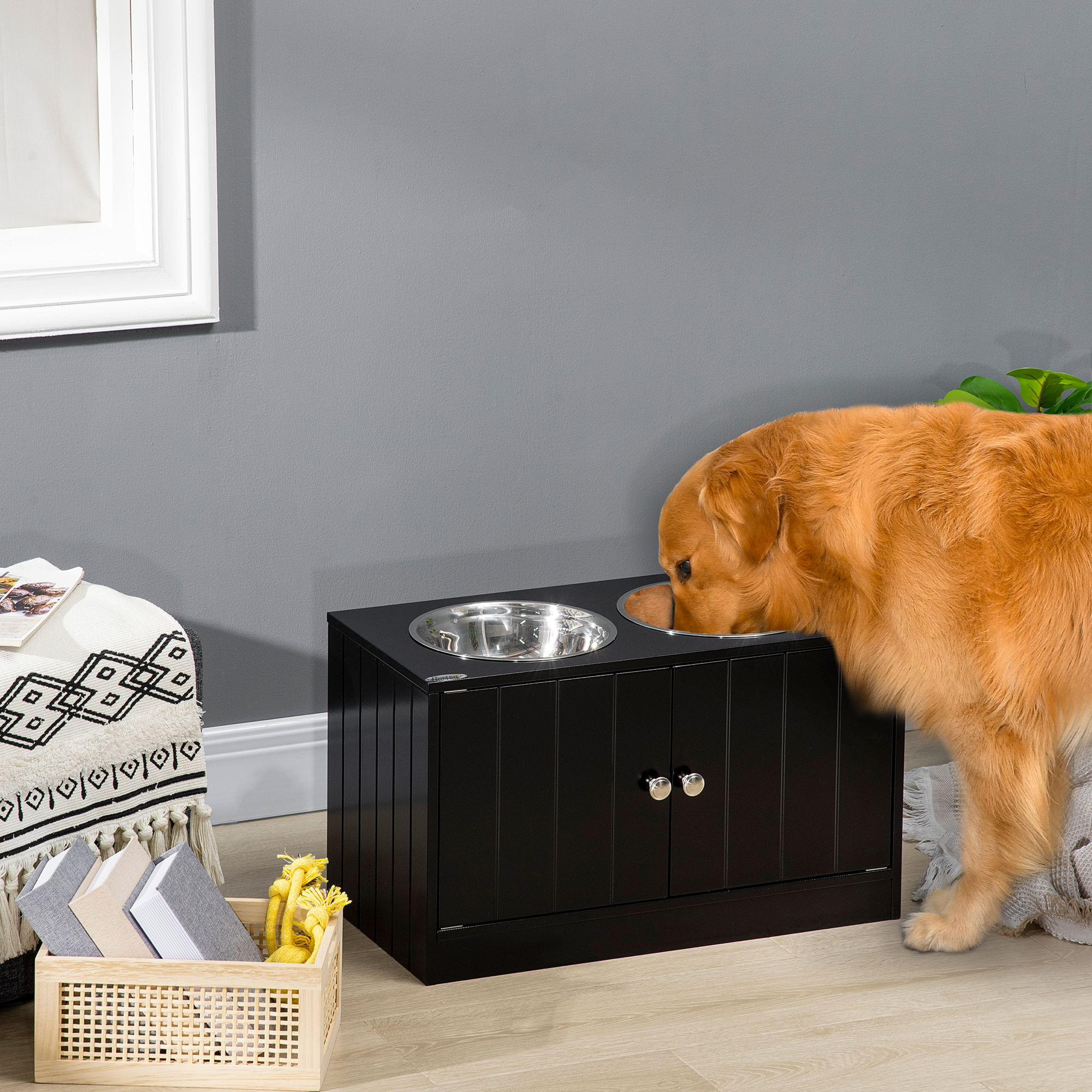 Un golden retriever mangia da una ciotola di metallo inserita in un mobile nero.