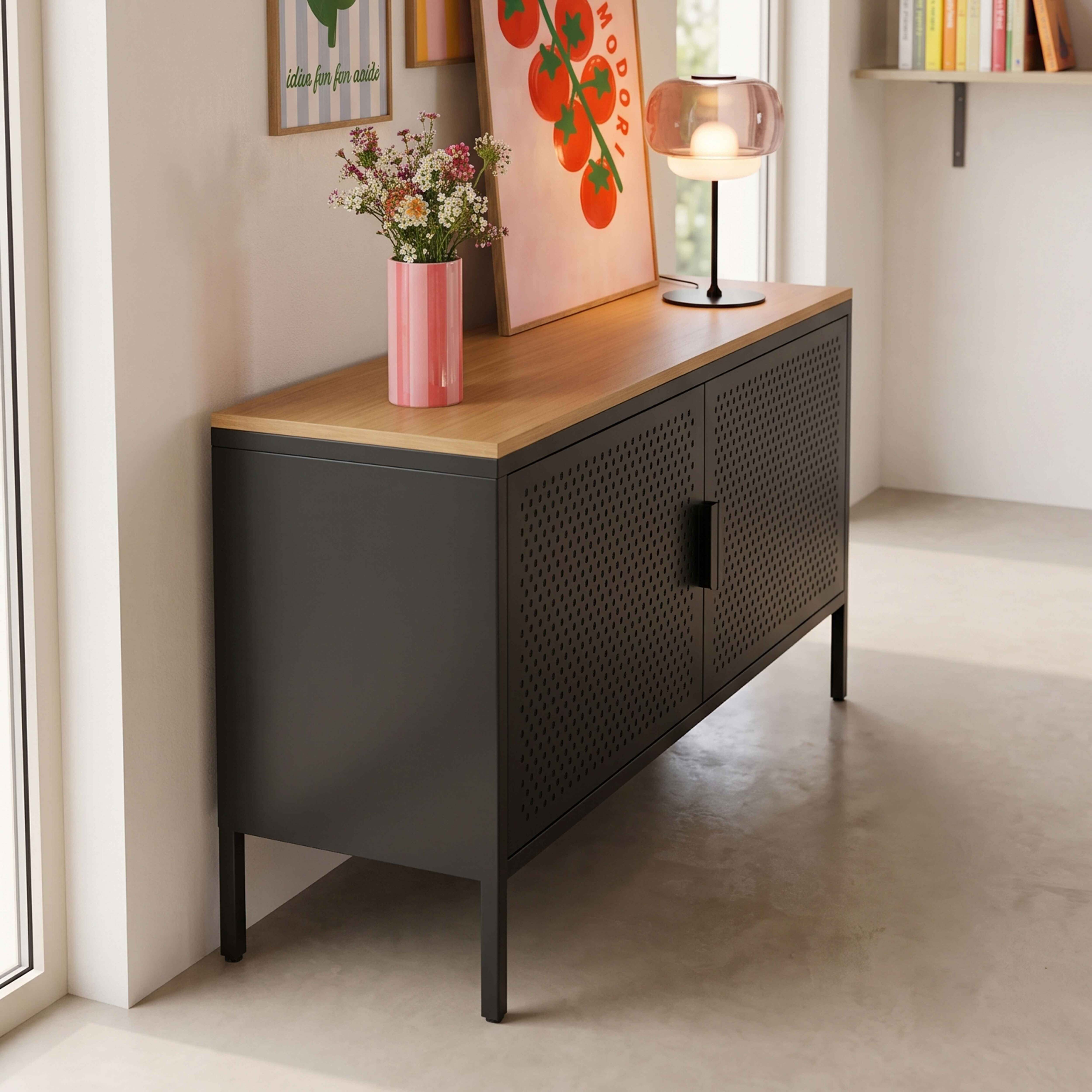 Schwarzer Metallschrank mit Holzplatte, darauf eine Vase mit Blumen und eine moderne Lampe.