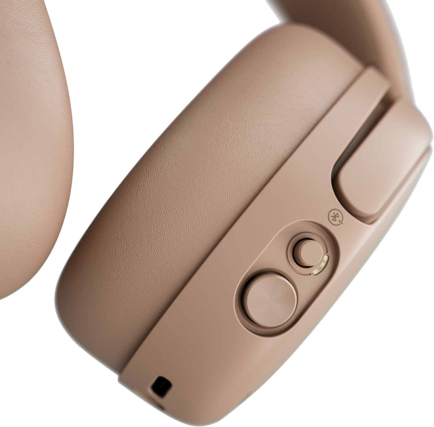 Primer plano de auriculares inalámbricos en color beige con botones visibles, interruptor y un icono de Bluetooth.