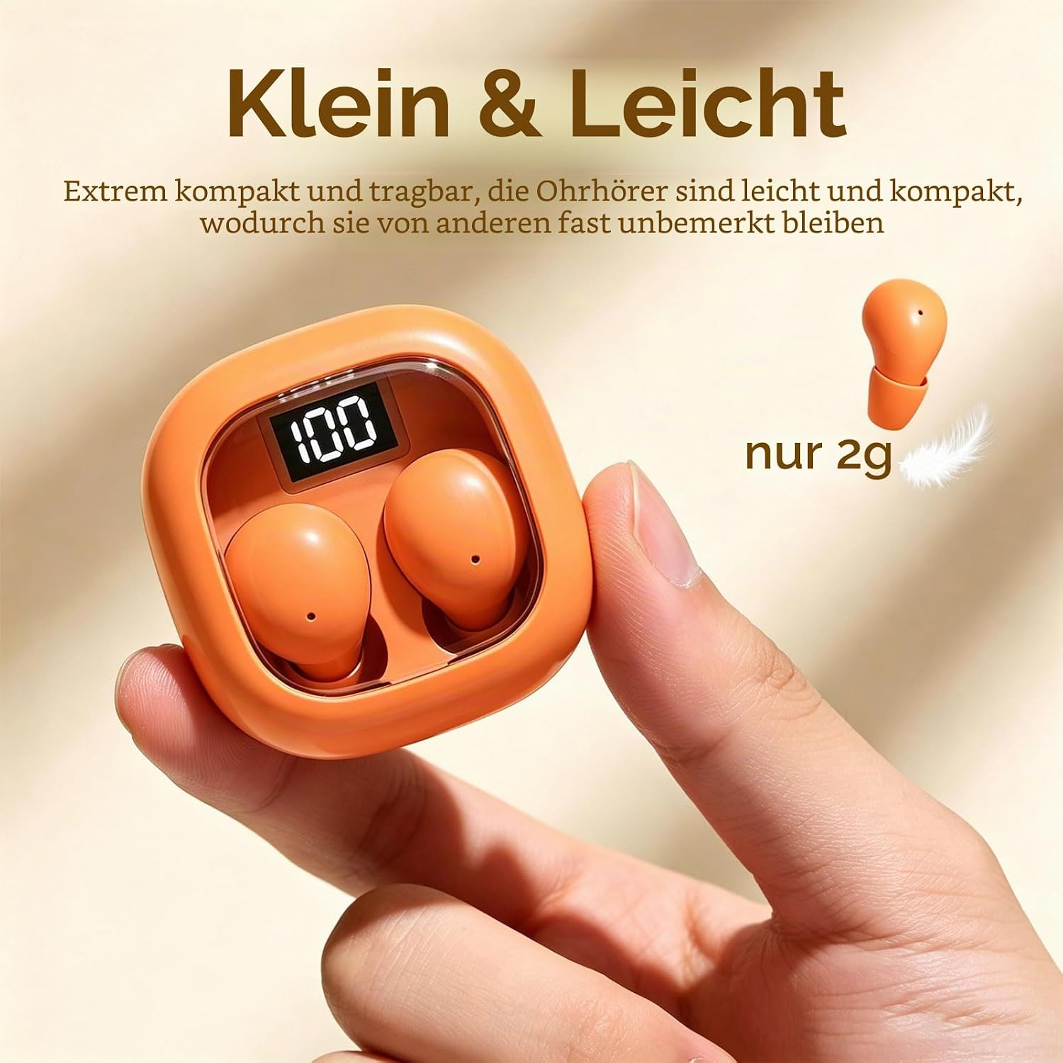Hand hält orangenes Ladeetui mit kabellosen Ohrhörern und digitaler Anzeige.
