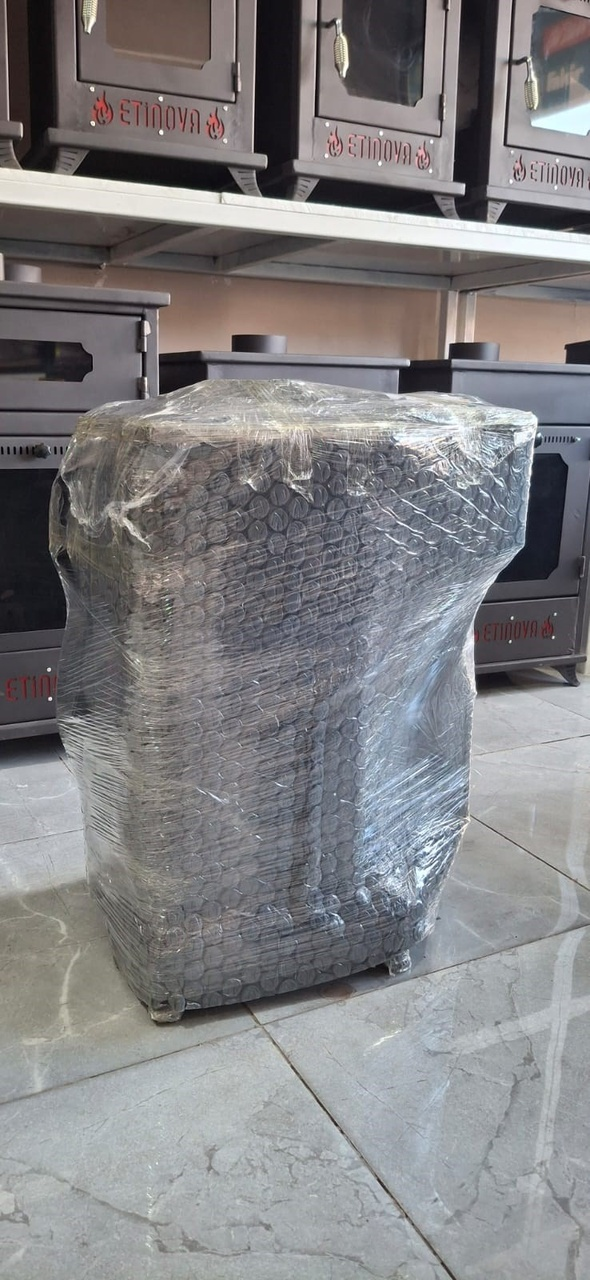 Odanın içinde patpata sarılmış bir soba var, arkada başka sobalar da görünüyor.