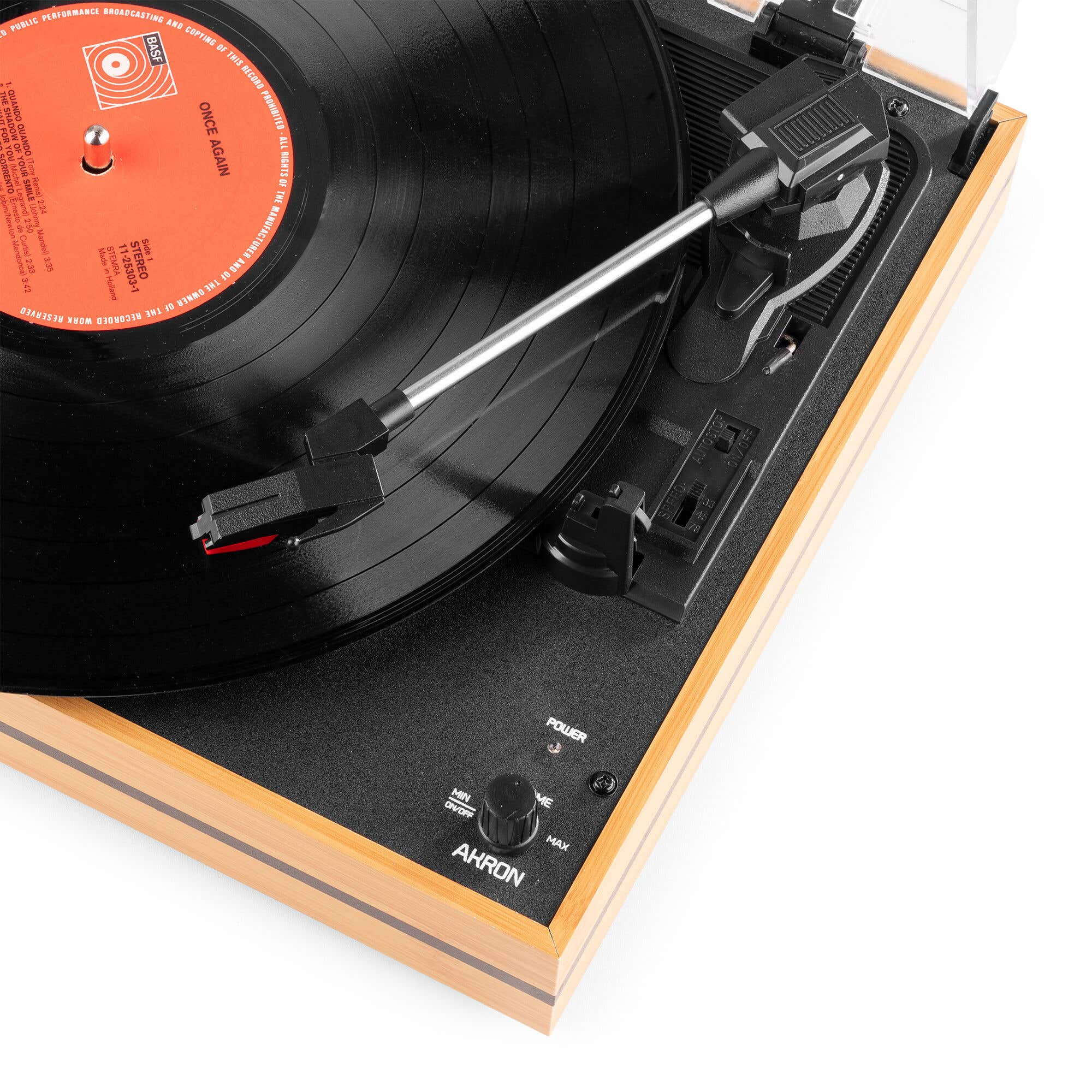 Un plato de vinilo de madera con un disco negro reproduciéndose, brazo plateado y botón de volumen sobre fondo blanco.