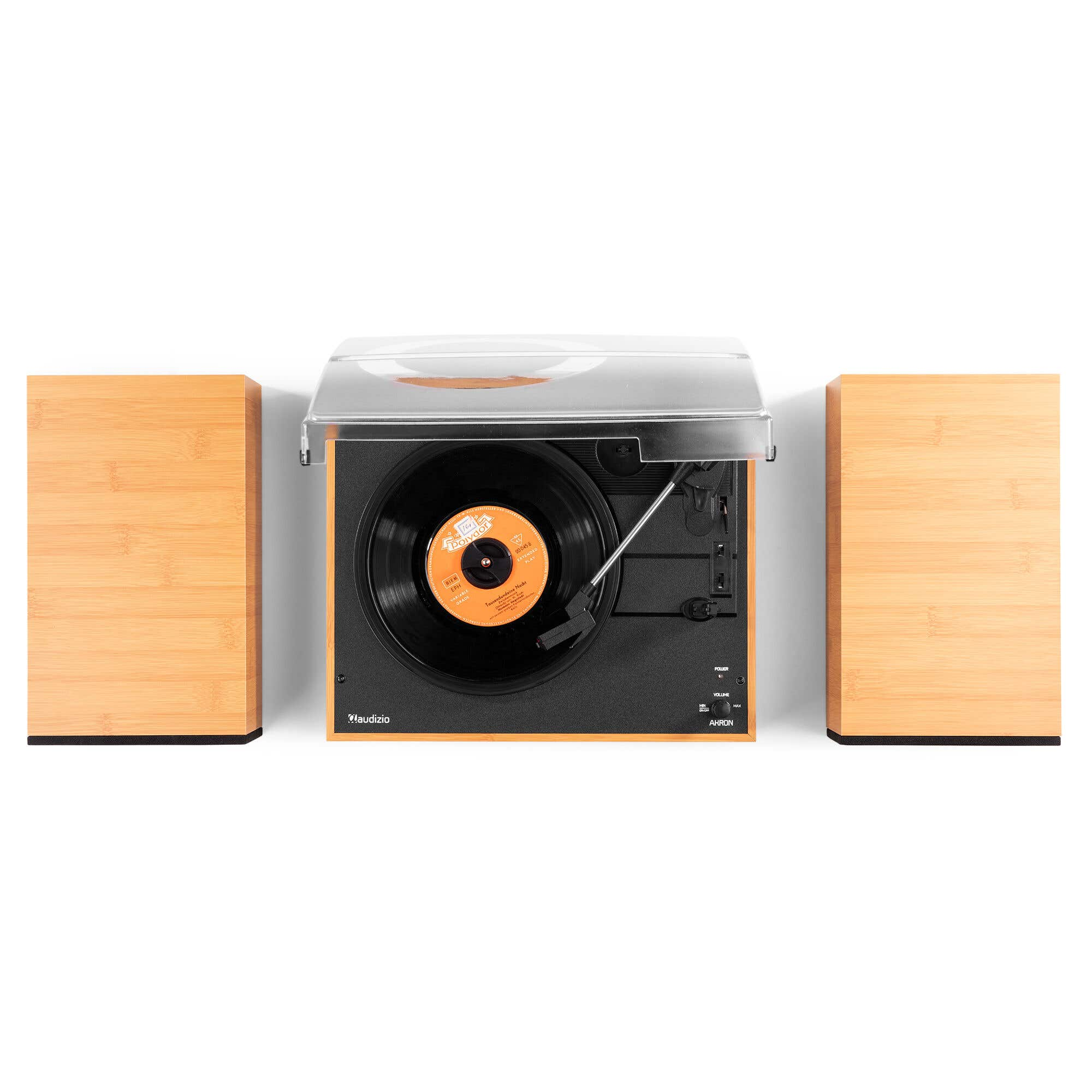 Un tocadiscos de madera con cubierta antipolvo transparente y dos altavoces de madera a juego sobre fondo blanco.