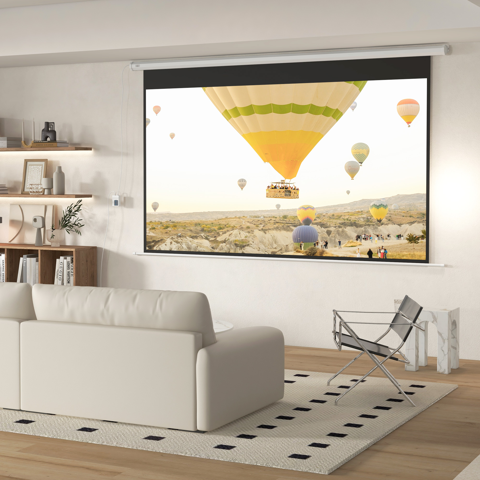 Soggiorno con divano beige, tappeto, poltrona e grande schermo di proiezione con mongolfiere.