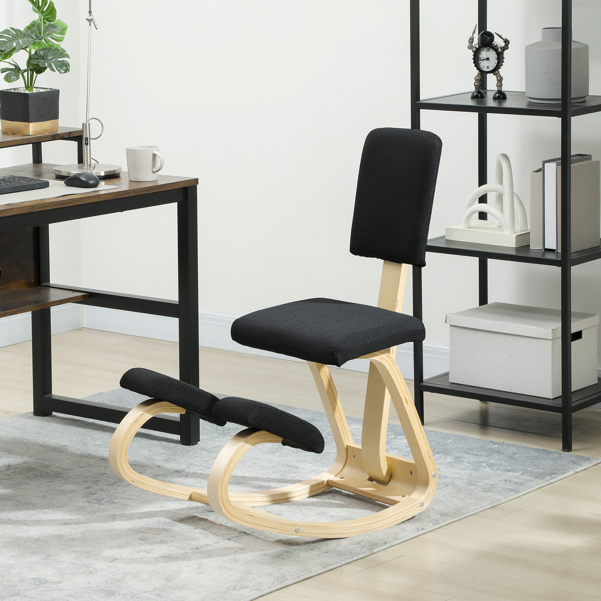 Una sedia ergonomica in tessuto nero e legno chiaro su un tappeto grigio, accanto a una scrivania e a una libreria.