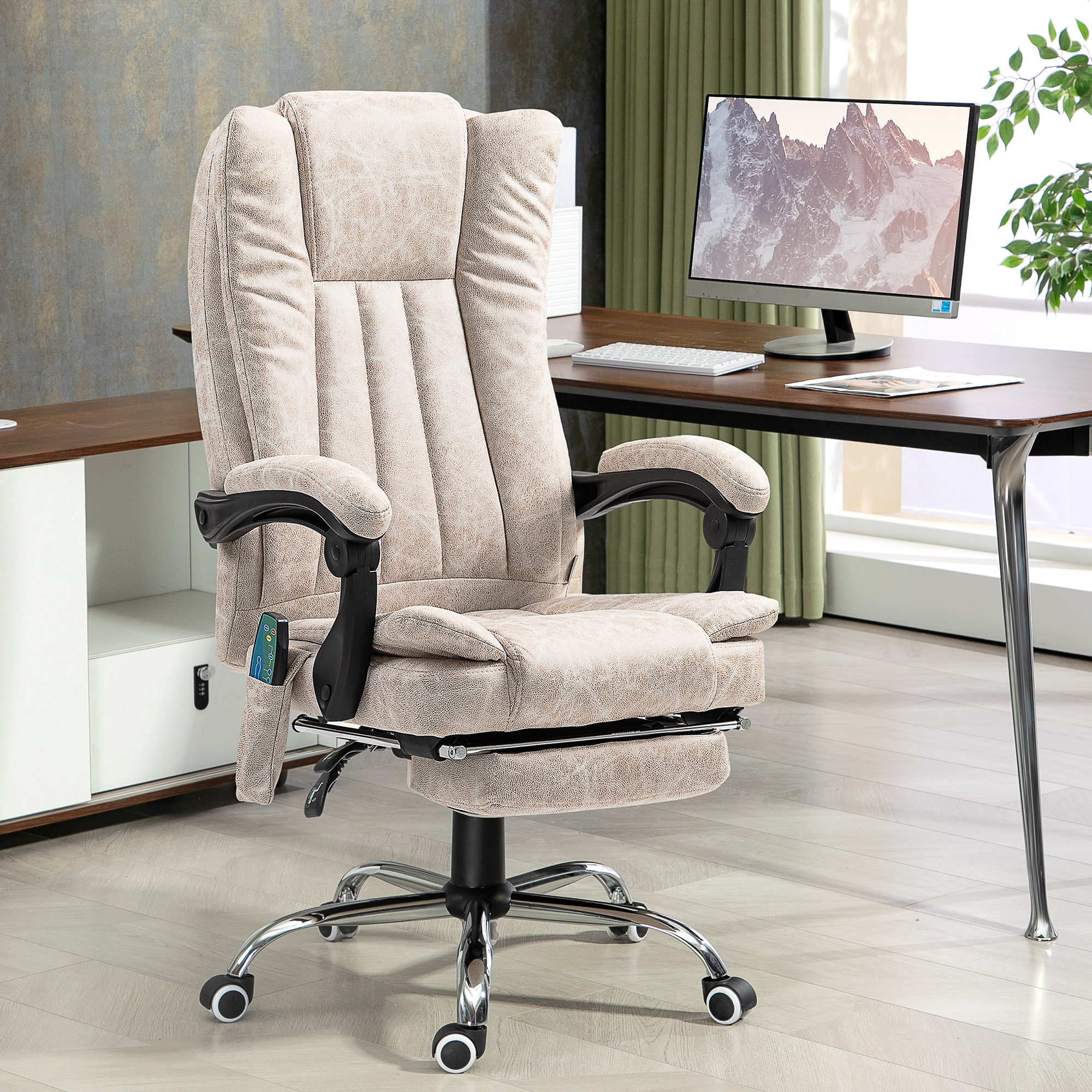 Sedia da ufficio direzionale beige con poggiapiedi davanti a una scrivania con monitor in una stanza luminosa.