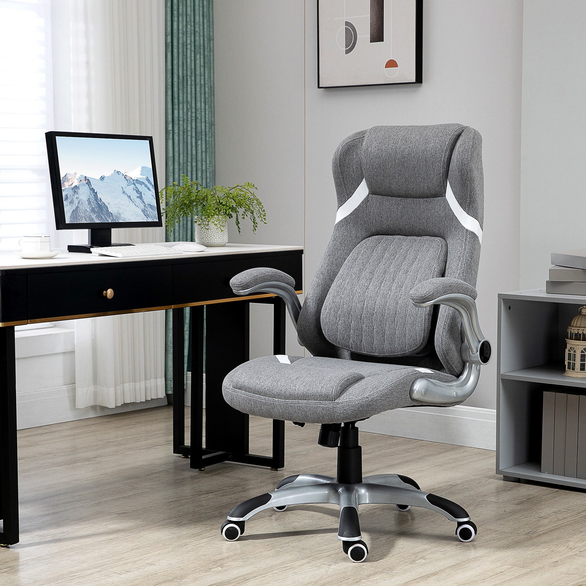 Una sedia da ufficio ergonomica grigia si trova davanti a una scrivania con un computer.