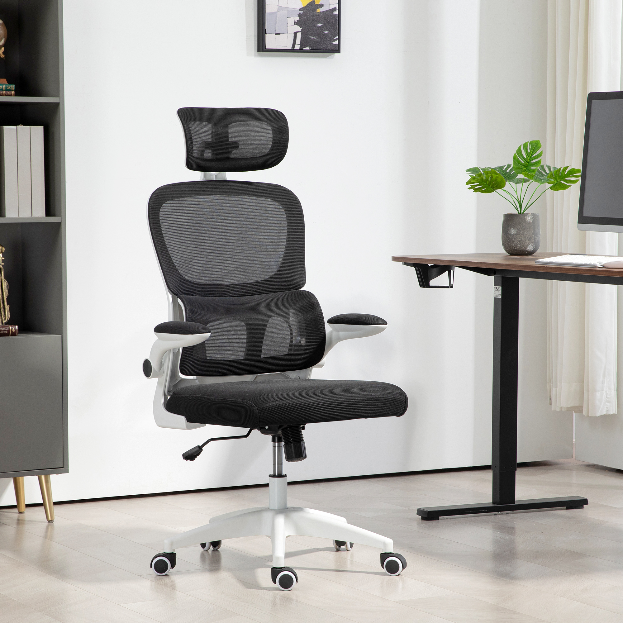 Una sedia da ufficio ergonomica nera e bianca con schienale in rete si trova in una stanza luminosa.