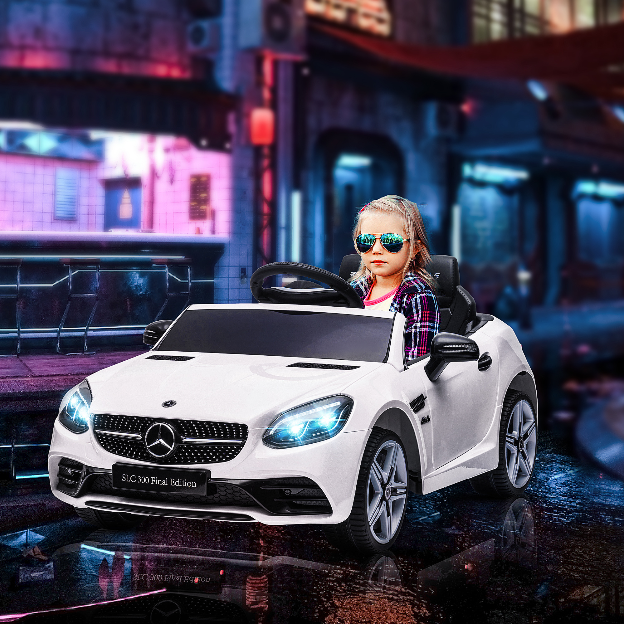 Una bambina con gli occhiali da sole siede in un'auto elettrica giocattolo bianca su una strada illuminata.