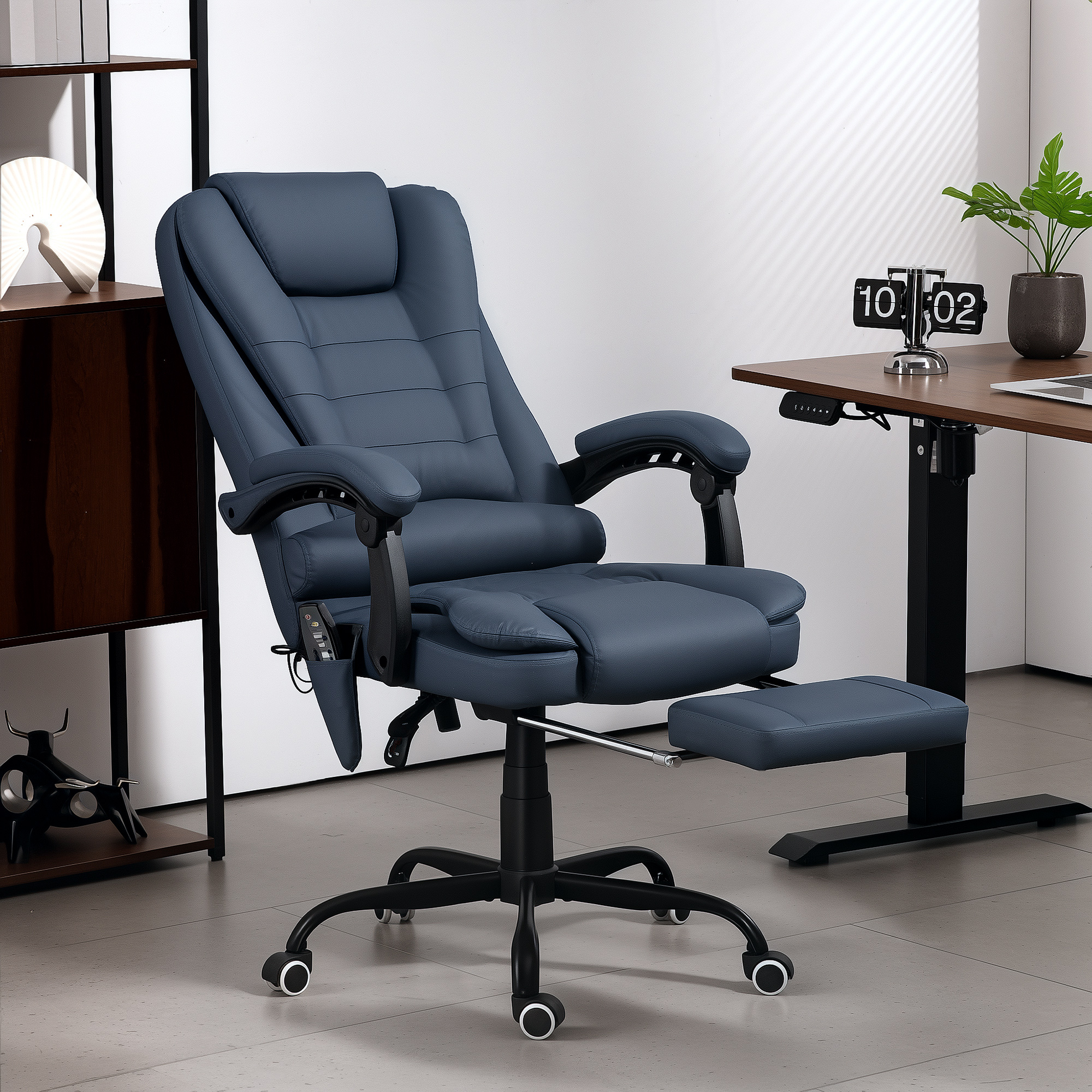 Una sedia da ufficio in pelle blu con poggiapiedi estraibile si trova in un ufficio moderno davanti a una scrivania.