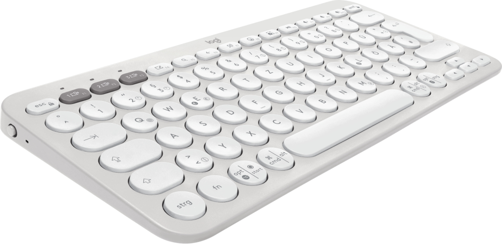 Una tastiera wireless grigia con tasti rotondi su una superficie bianca.