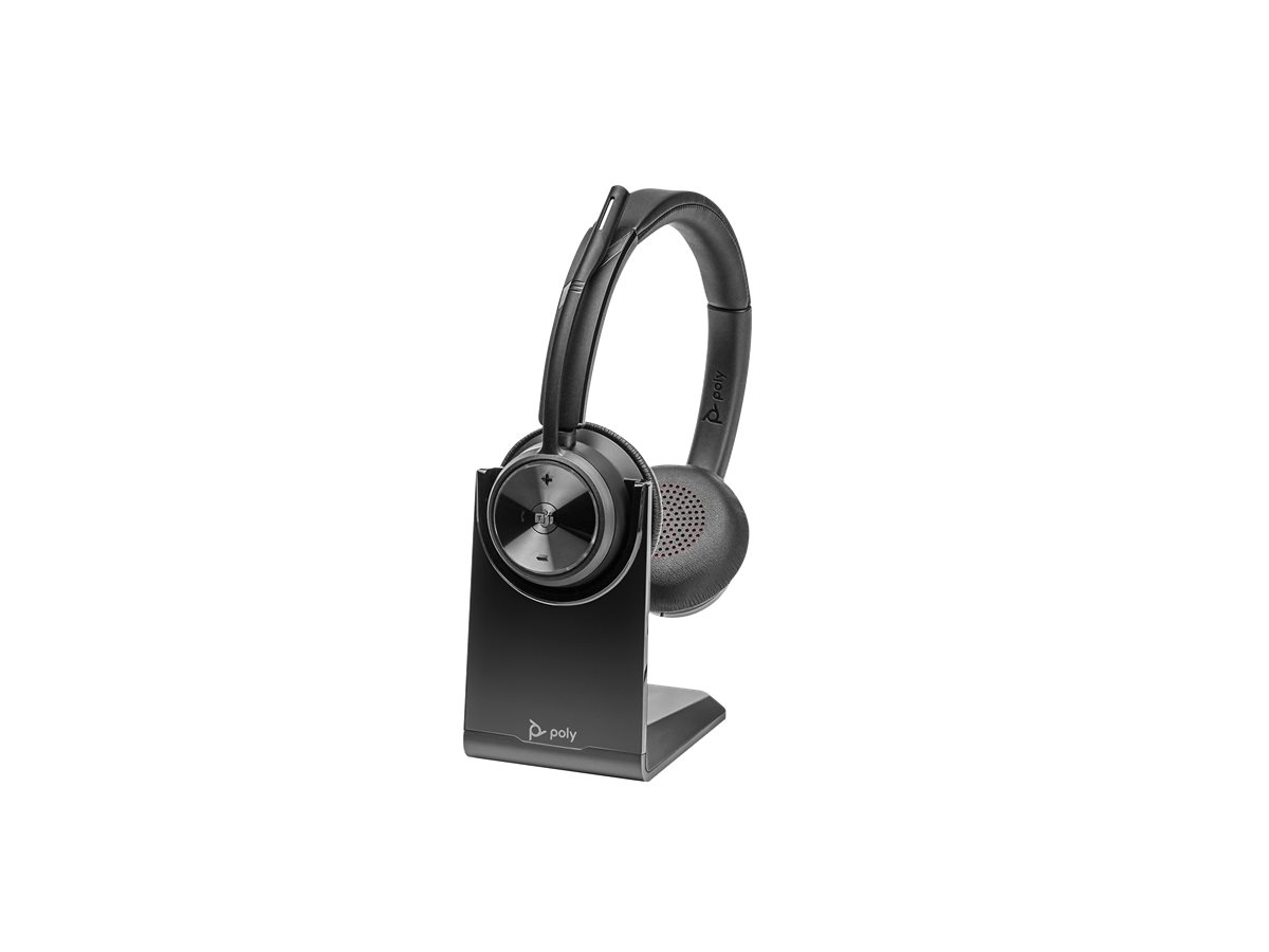 Casque Poly noir posé sur un support de charge assorti sur fond blanc.