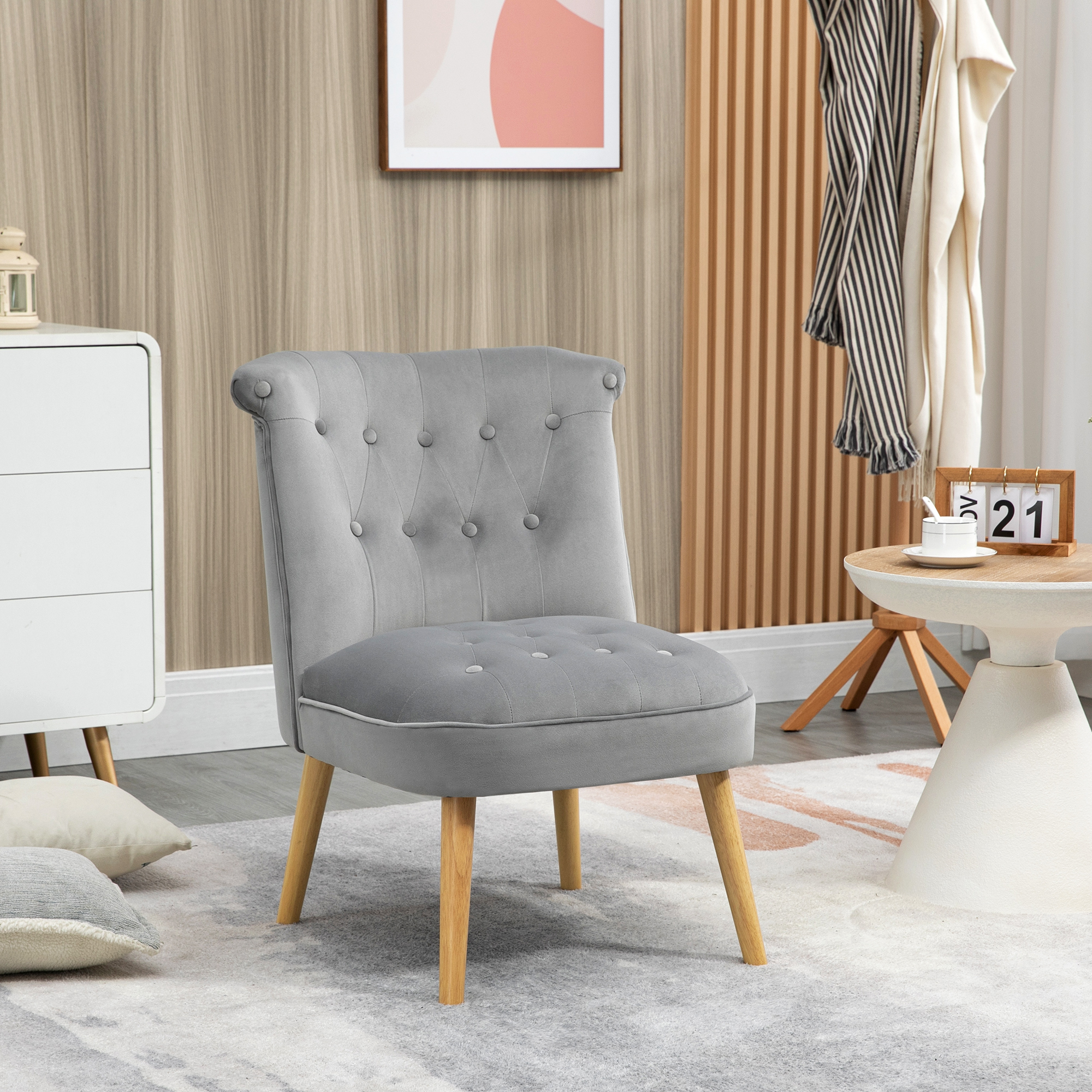 Una poltrona grigia con gambe in legno poggia su un tappeto decorato in un soggiorno moderno.