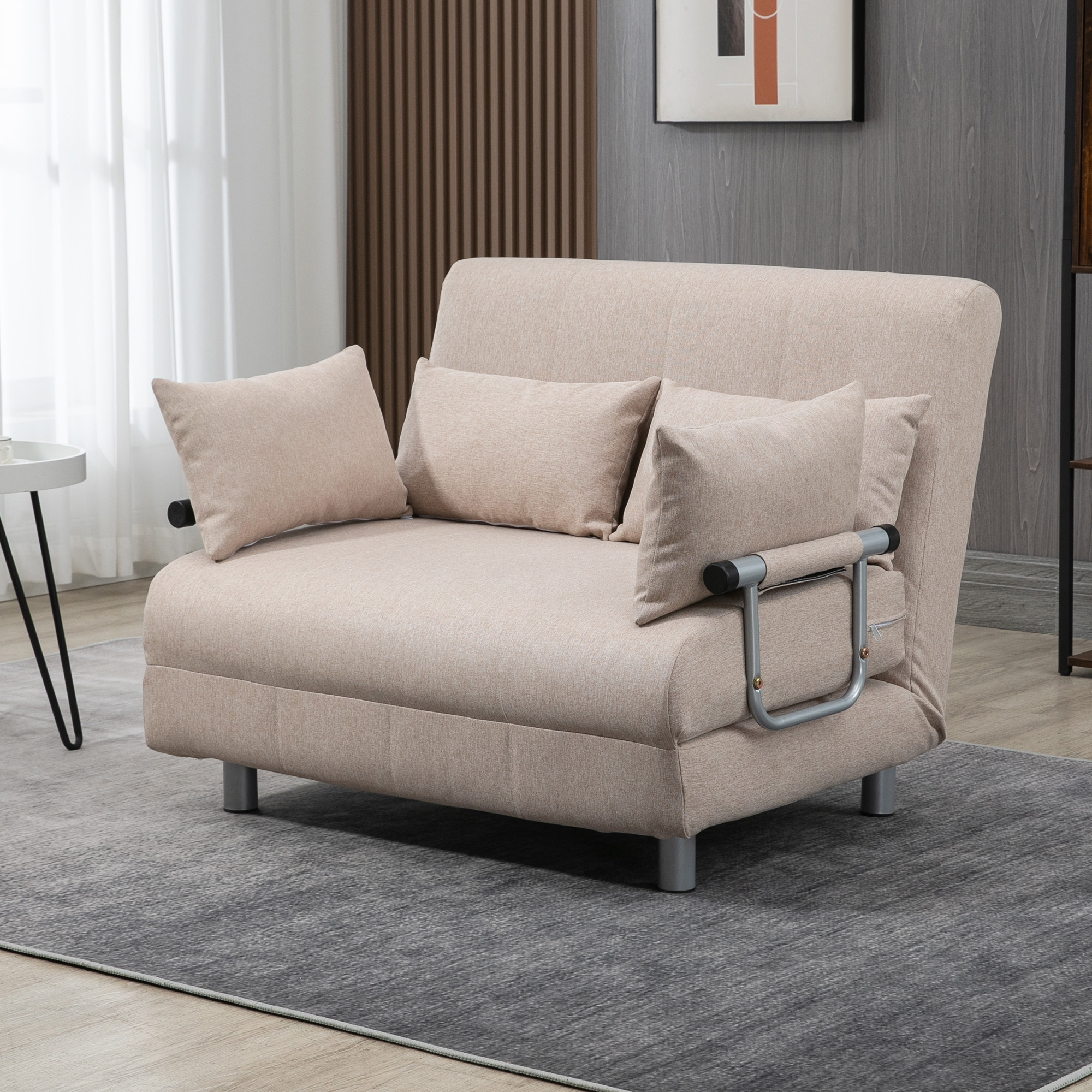 Poltrona letto beige con cuscini su tappeto grigio in una stanza con parete in legno.