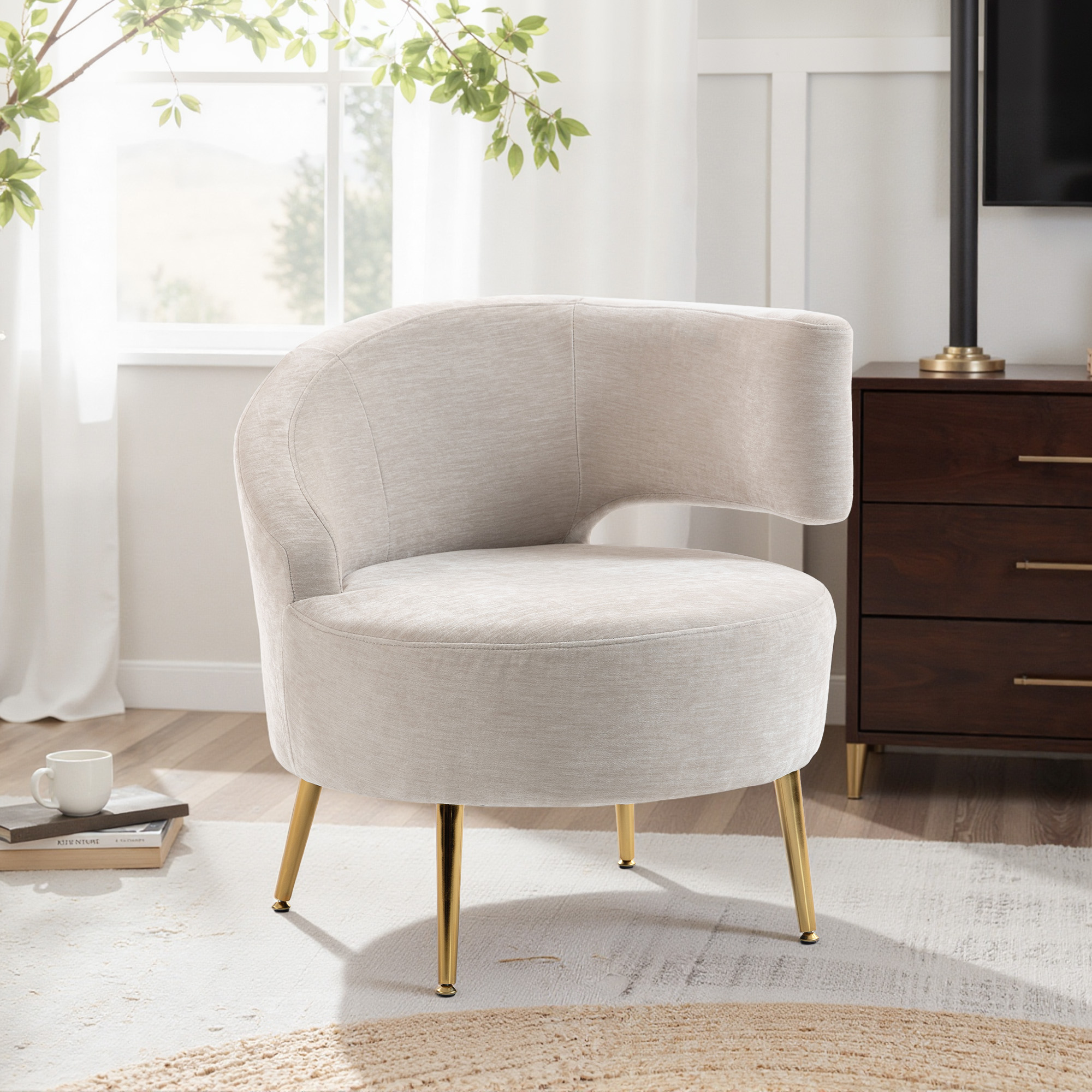 Poltrona beige con gambe dorate su un tappeto in una stanza luminosa.
