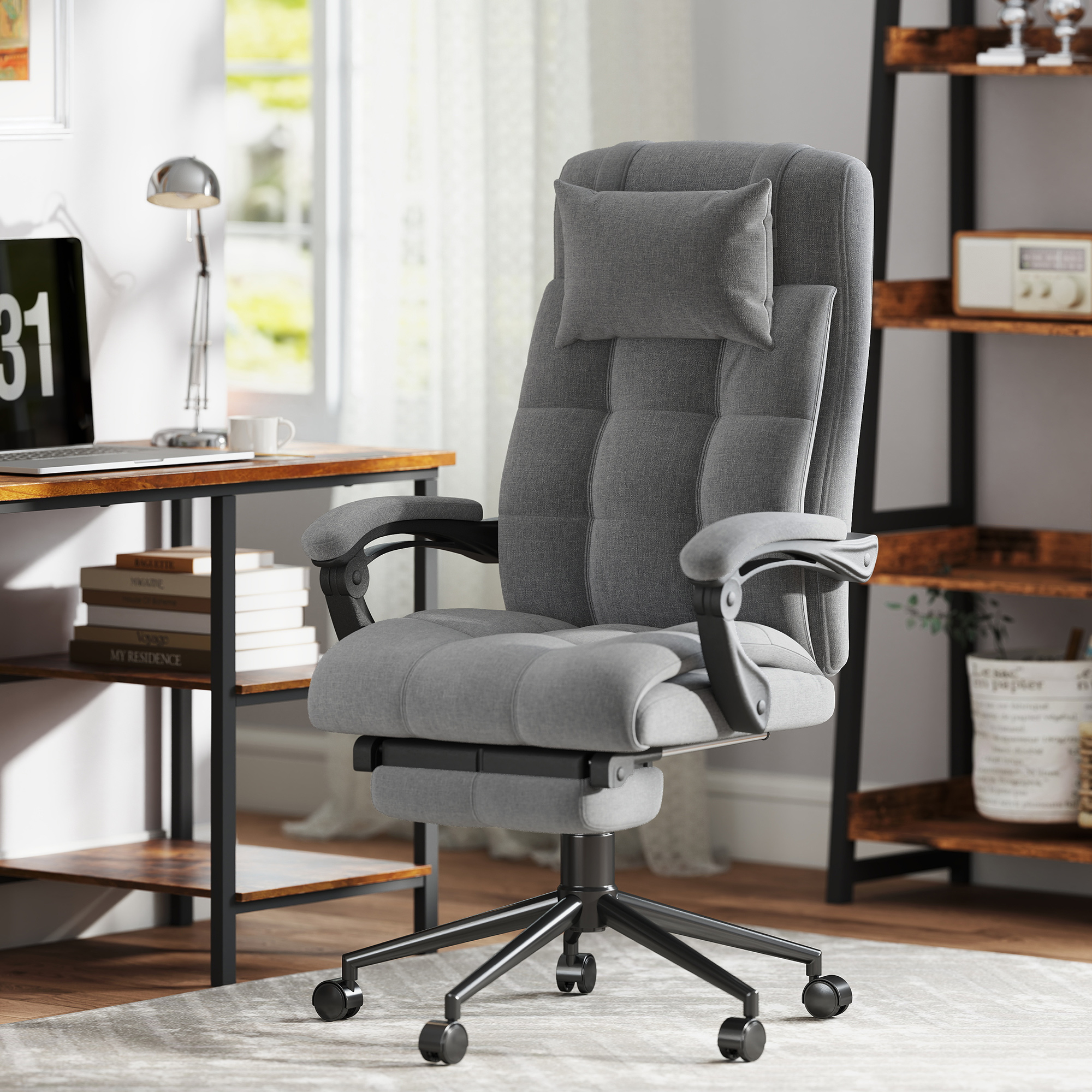 Una sedia da ufficio ergonomica grigia con cuscino, poggiapiedi e base nera con ruote in un ufficio.