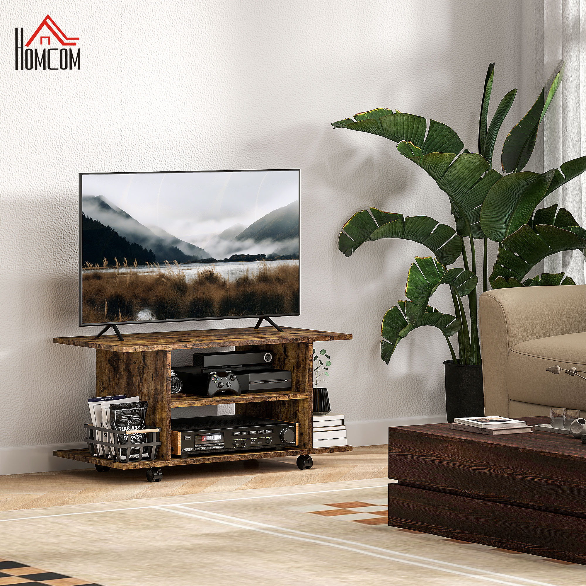 Un mobile TV in legno con dispositivi elettronici in un soggiorno, accanto a una grande pianta e un divano.