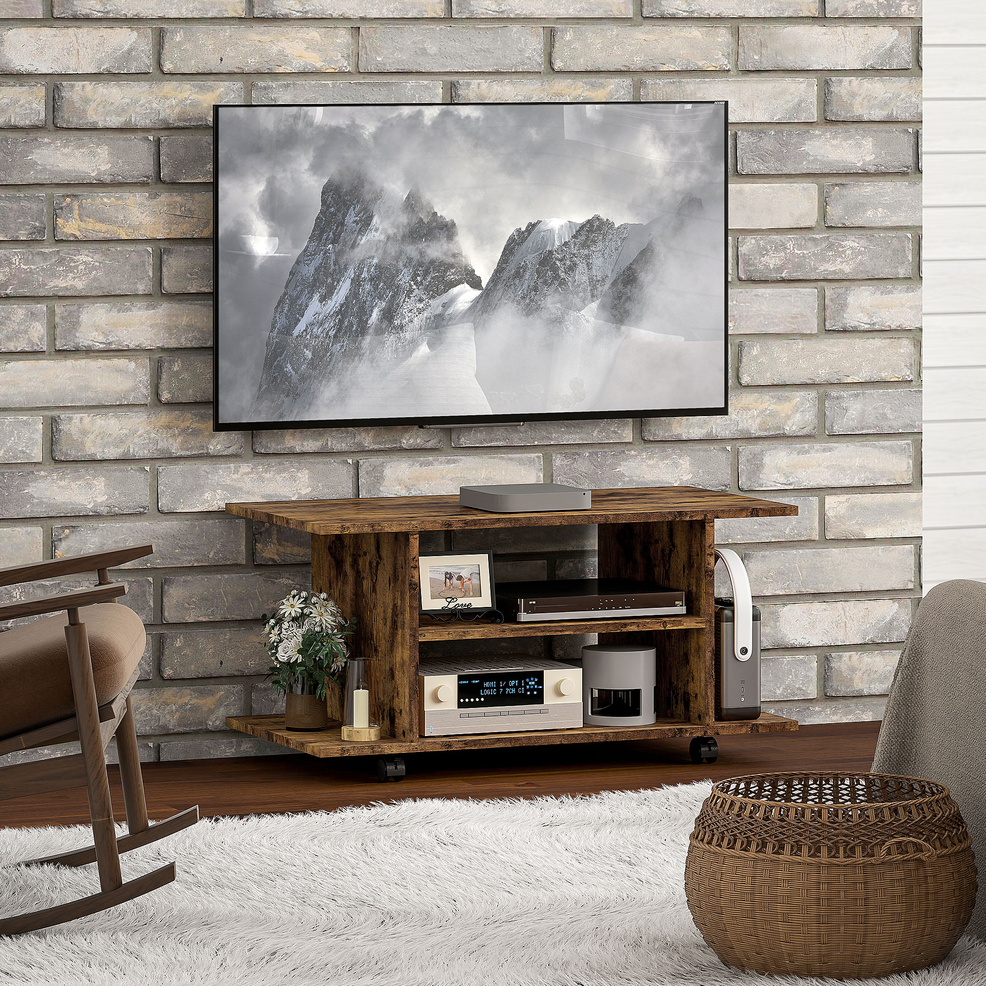 Una TV con montagne innevate su un mobile in legno rustico davanti a una parete in mattoni su un tappeto bianco.