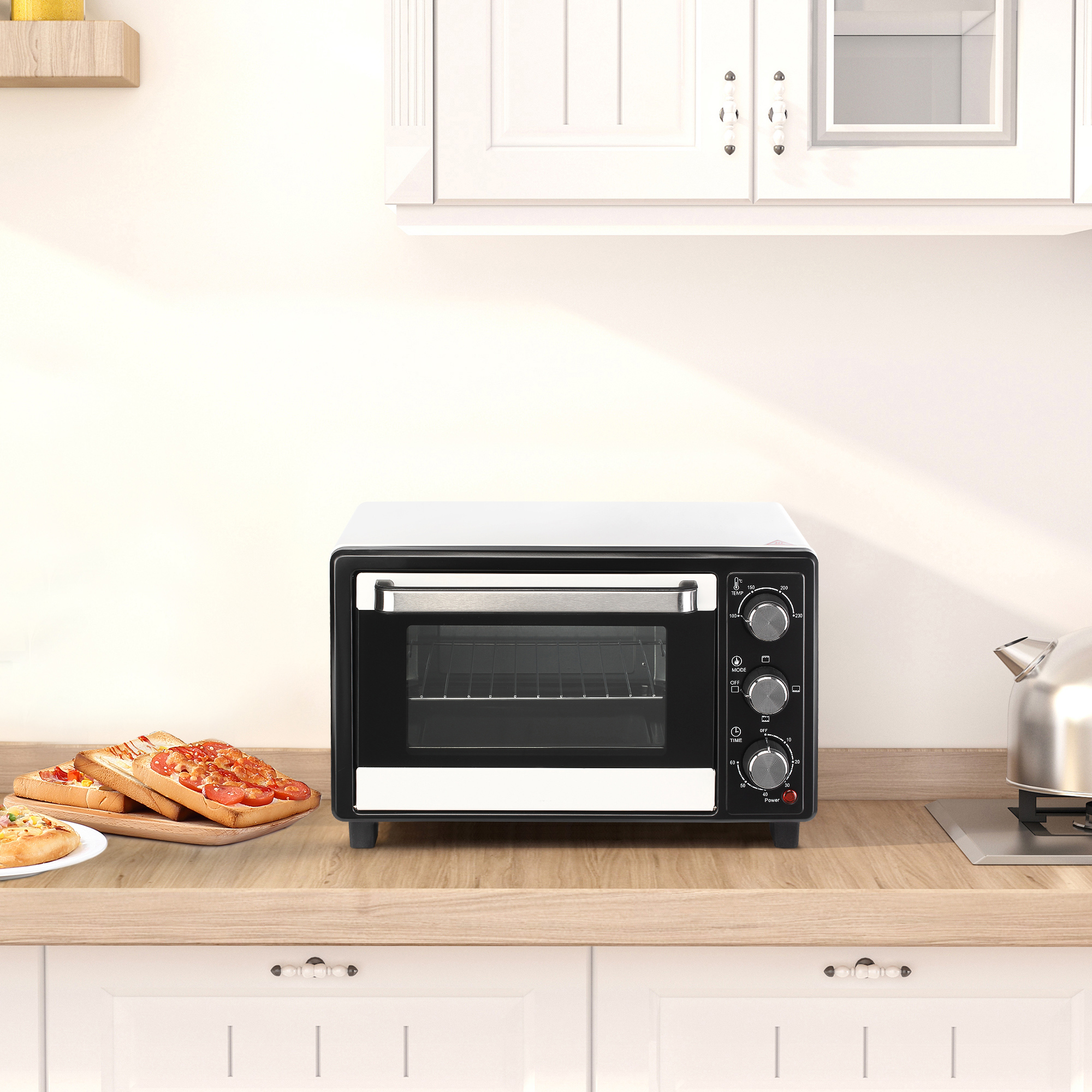 Un mini forno bianco e nero su un piano di lavoro in legno in una cucina moderna, con fette di pane tostato accanto.