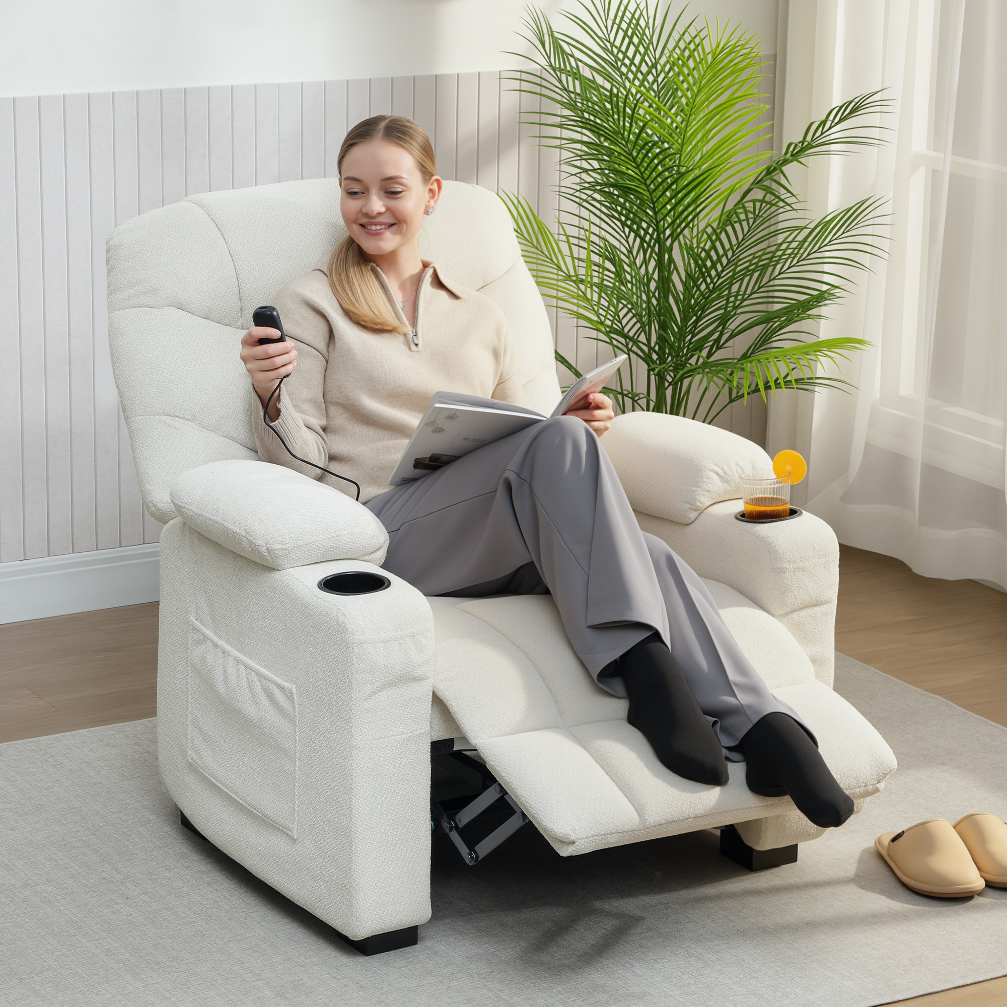 Una donna sorridente su una poltrona legge una rivista e tiene un telecomando, con una pianta sullo sfondo.