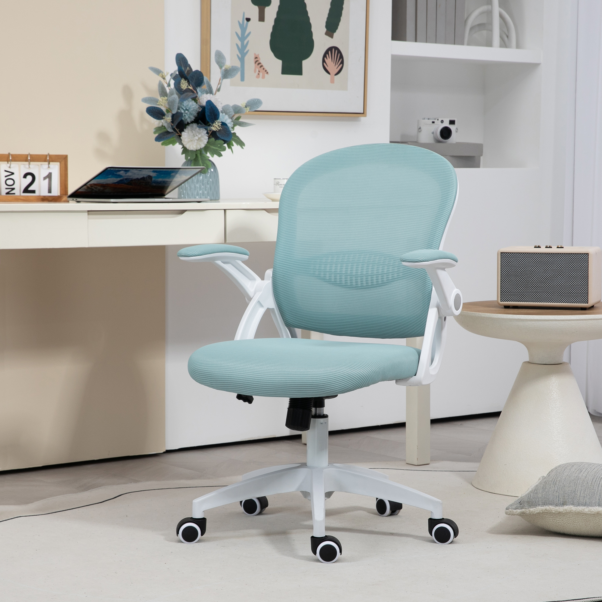 Una sedia da ufficio azzurra con struttura bianca e ruote in una stanza moderna con scrivania e scaffali.