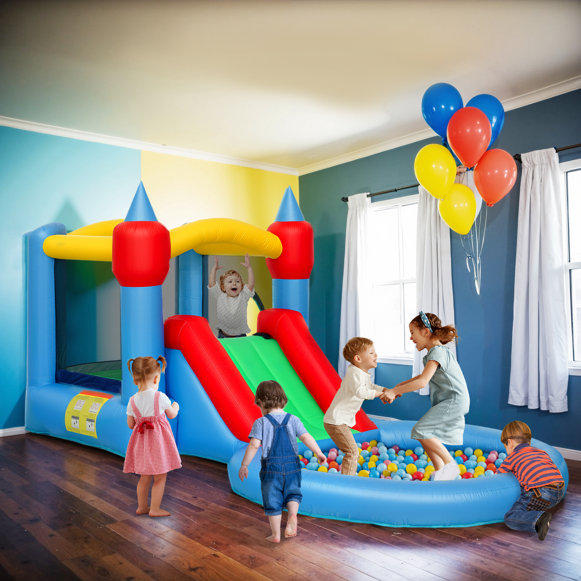 Cinque bambini giocano in una stanza con un castello gonfiabile colorato, scivolo e piscina di palline.