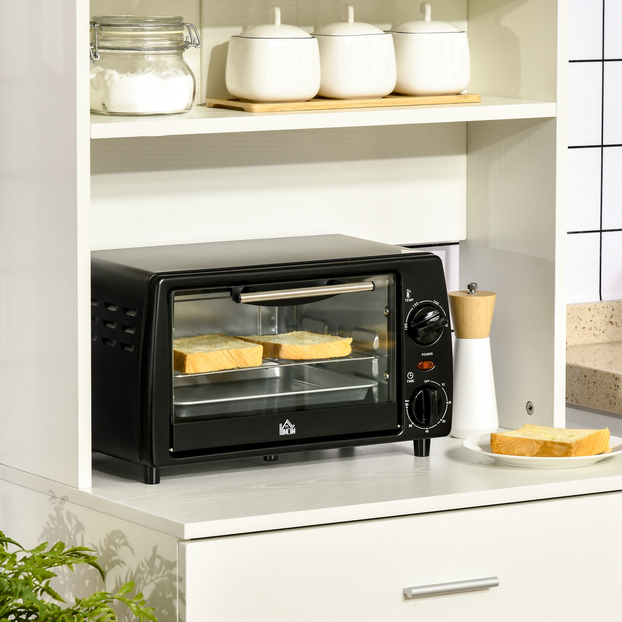 Un piccolo forno tostapane nero su un bancone da cucina bianco con fette di pane all'interno.