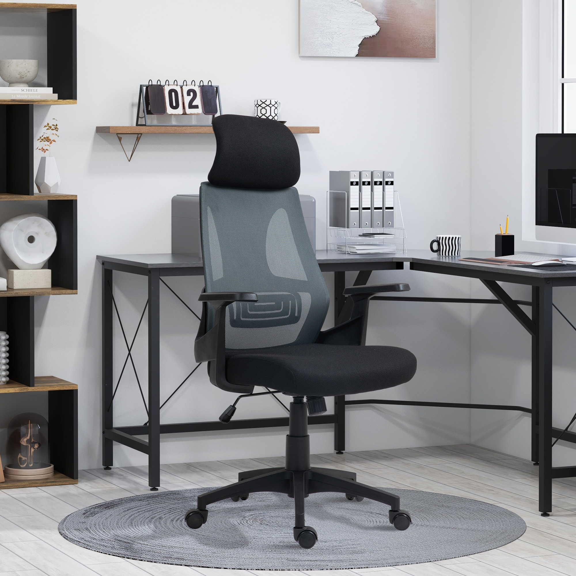 Una sedia da ufficio ergonomica nera e grigia su un tappeto rotondo in un ufficio moderno con scrivania.