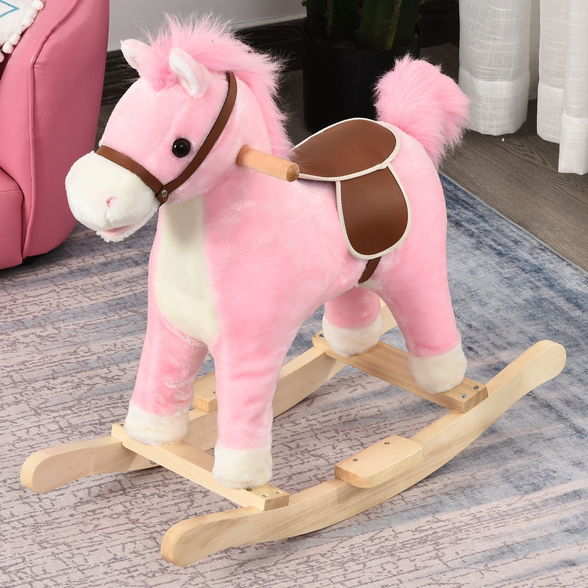 Un cavallo a dondolo rosa di peluche con sella marrone su un tappeto.