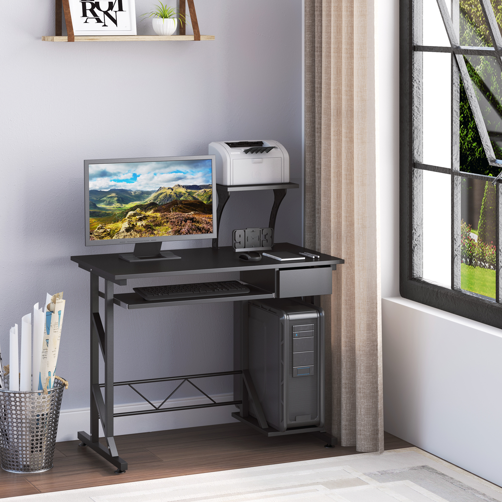 Una scrivania nera per computer con monitor, PC, stampante e tastiera.