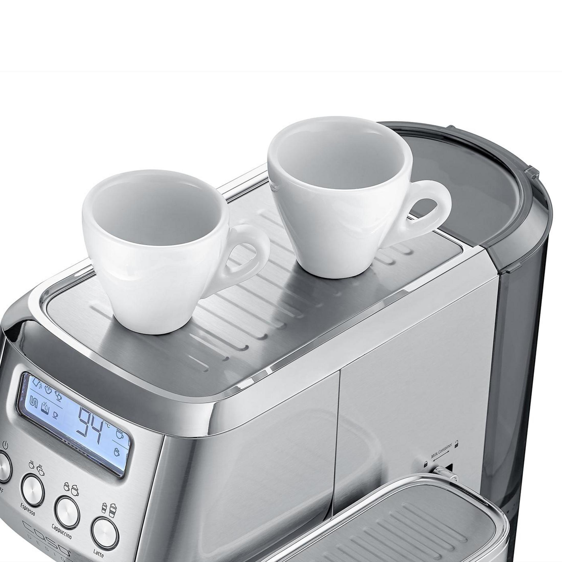 Zwei weiße Kaffeetassen stehen auf der oberen Edelstahlfläche einer silbernen Kaffeemaschine mit digitalem Display.