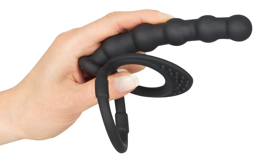 Eine Hand hält ein schwarzes, genopptes Silikon-Sexspielzeug mit Ring.