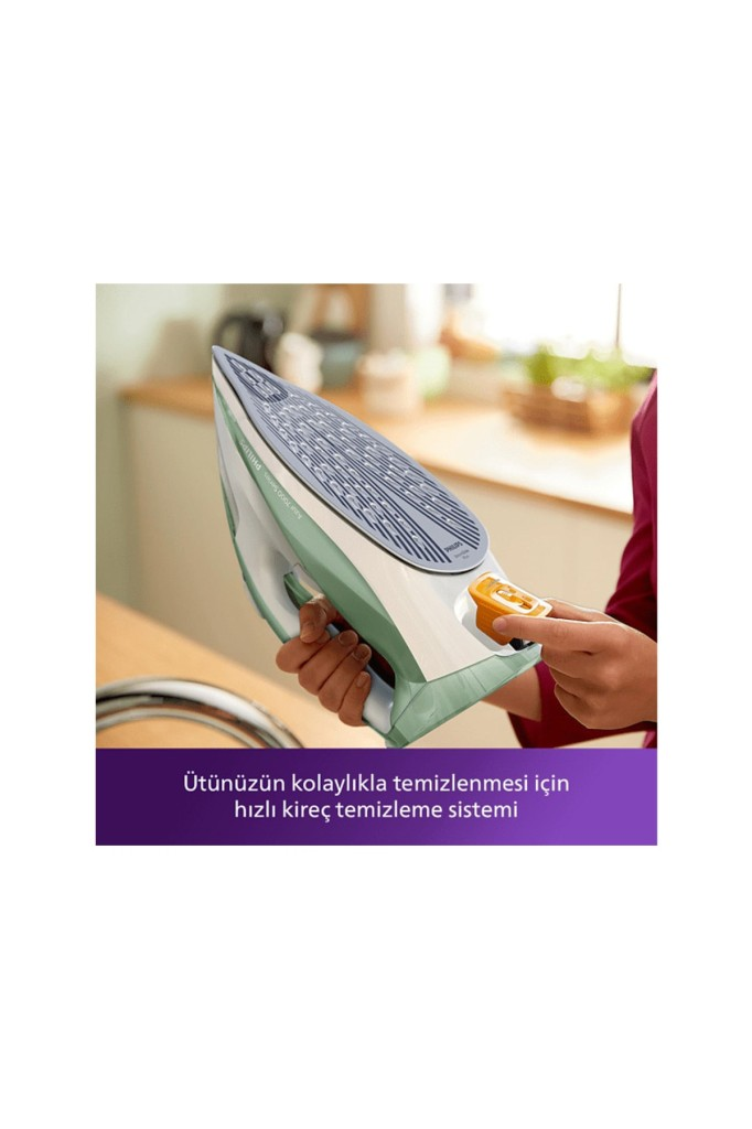Bir kişi mutfakta sarı kireç haznesi olan beyaz ve yeşil ütüyü tutuyor.