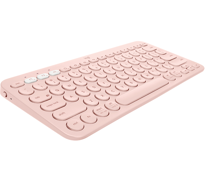 Una tastiera wireless rosa chiaro con tasti rotondi su una superficie bianca.