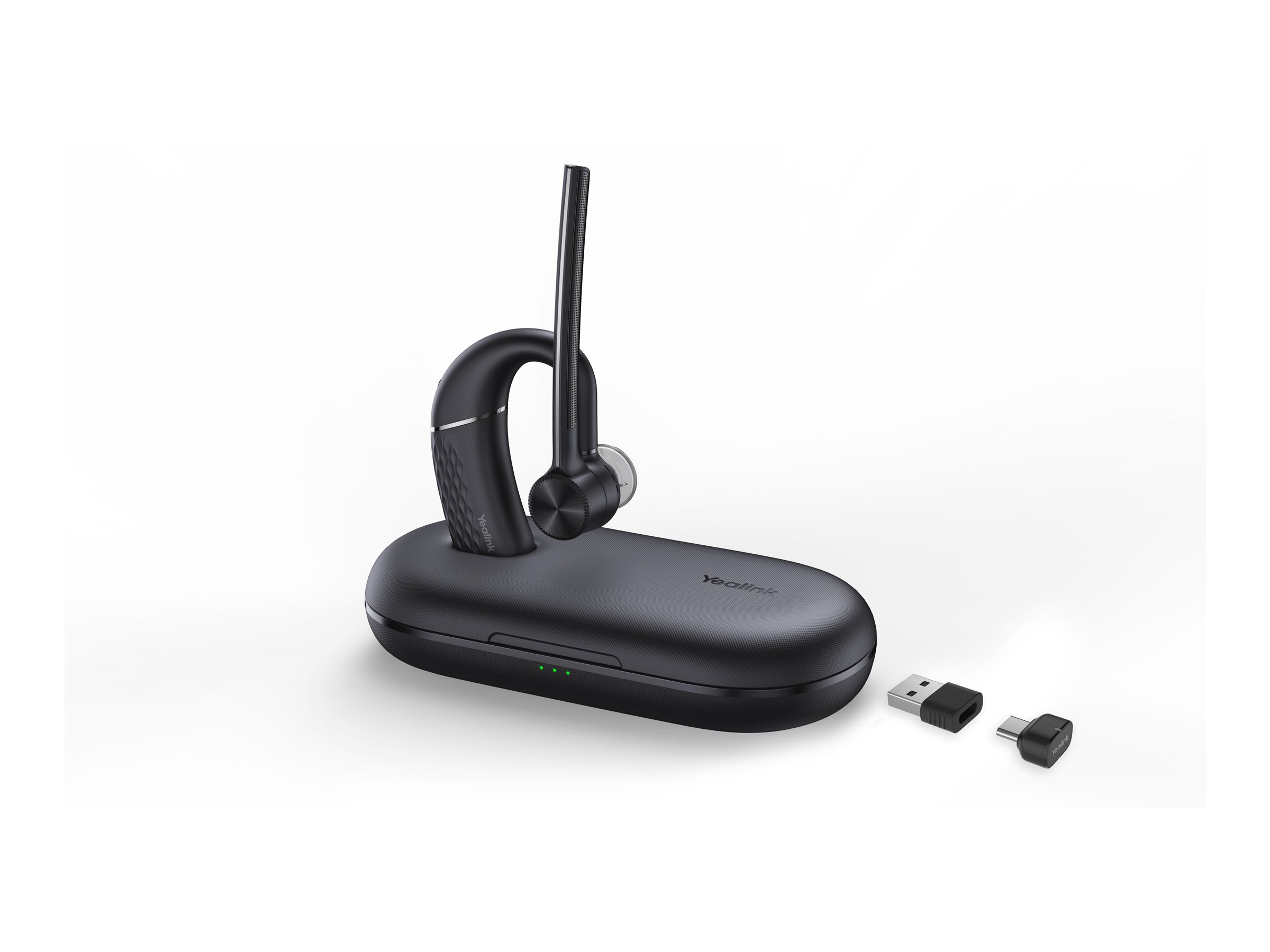 Casque sans fil noir sur sa base de charge avec un adaptateur USB, sur fond blanc.
