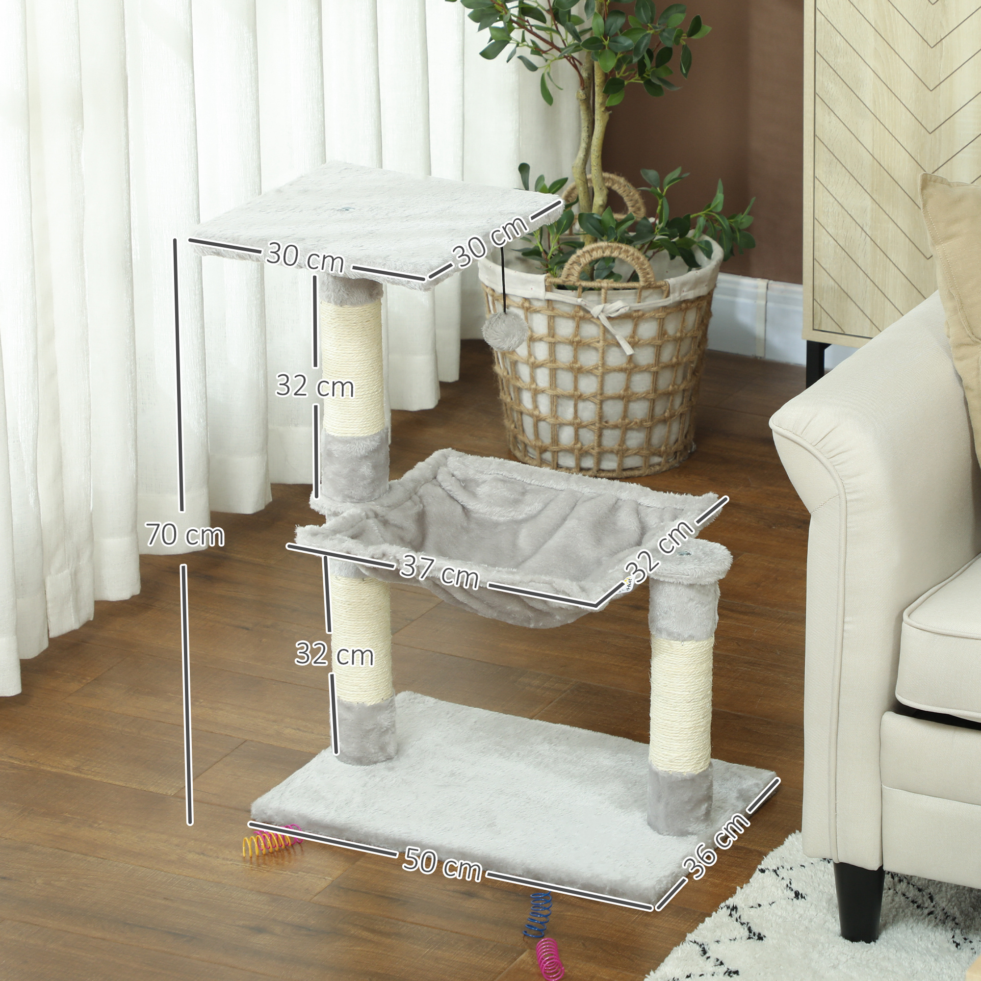 Árbol para gatos gris con dimensiones en suelo de madera, con cesta de planta y sofá al fondo.