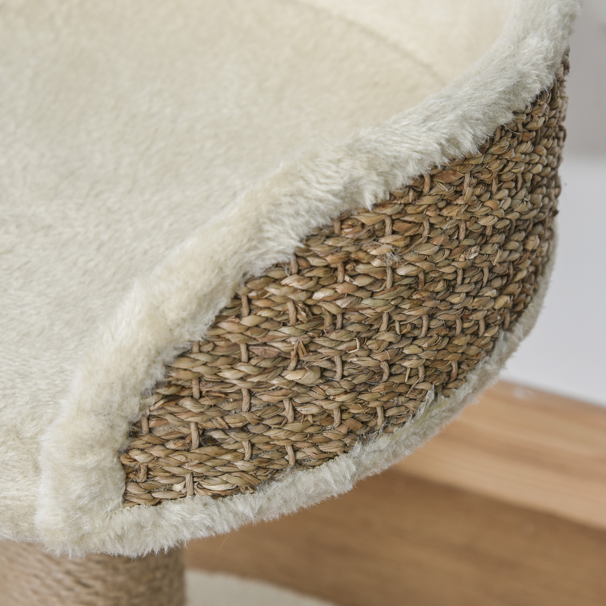 Primer plano de la base de una cesta para gatos tejida con un cojín suave.