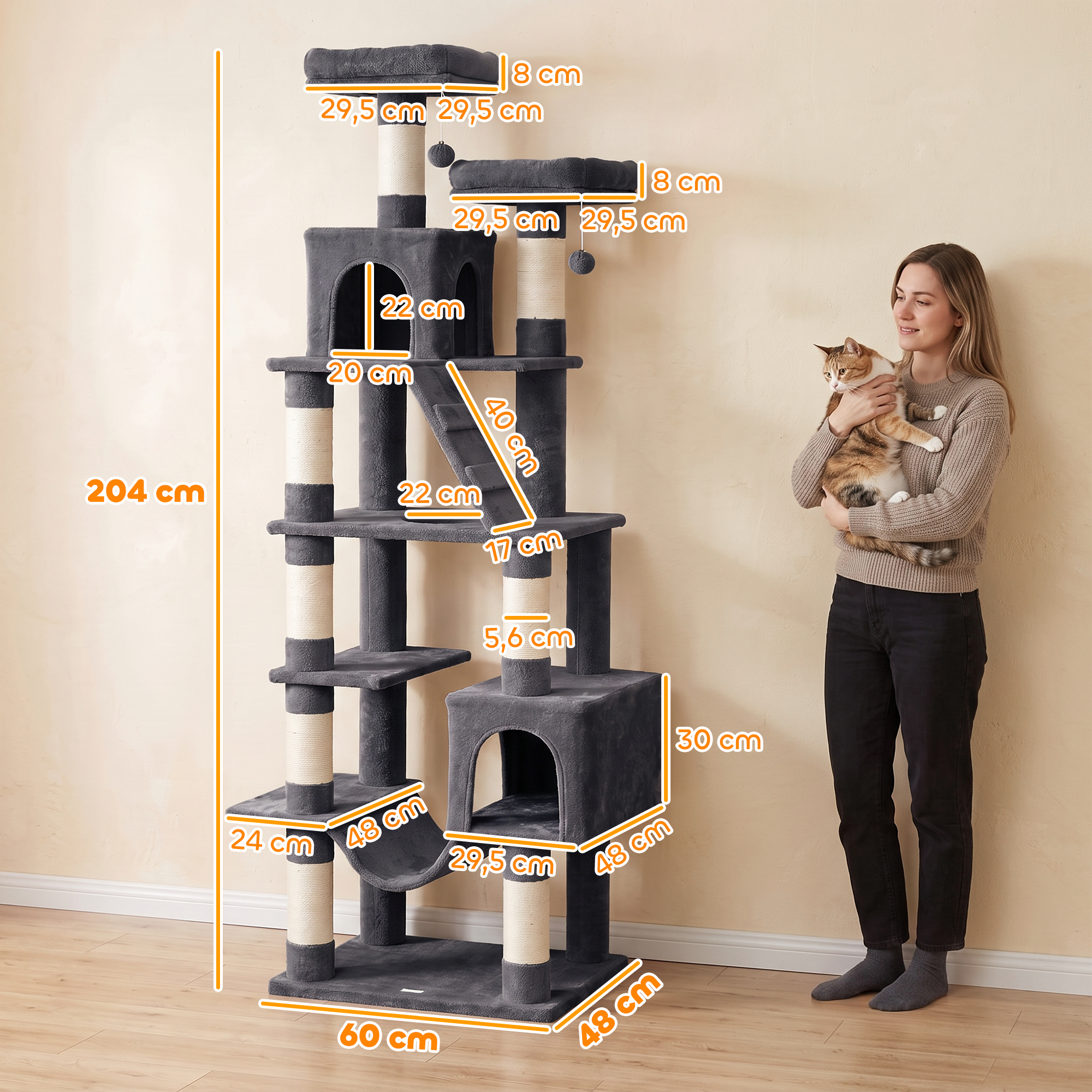 Una mujer con un gato está junto a un gran árbol para gatos gris con medidas.