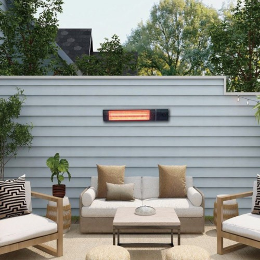 Un patio exterior con un calefactor iluminado montado en una pared gris, un sofá blanco y sillones.