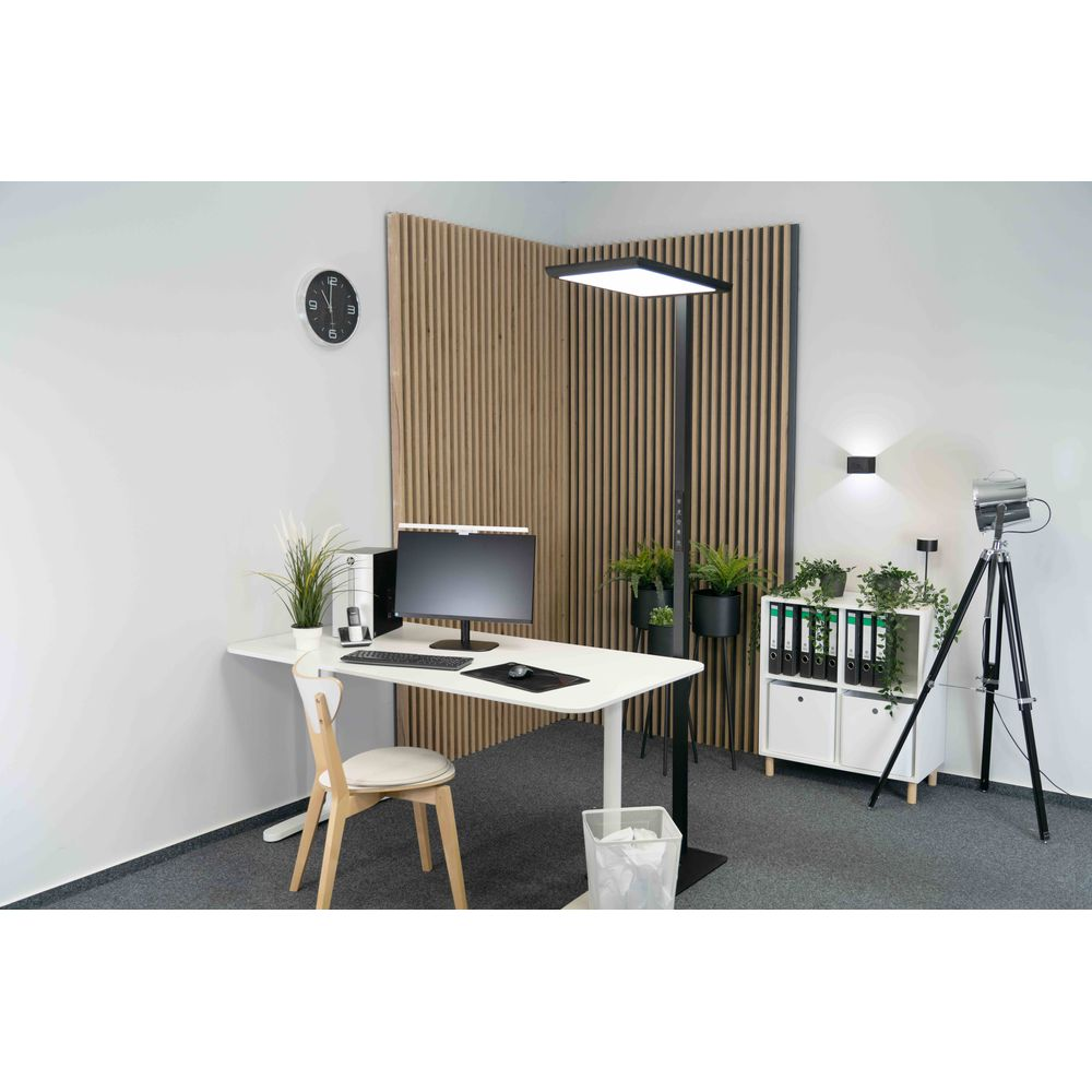 Moderne Büro-Ecke mit weißem Schreibtisch, Monitor, Holzstuhl, großer Stehlampe und vertikalen Holzpaneelen an der Wand.