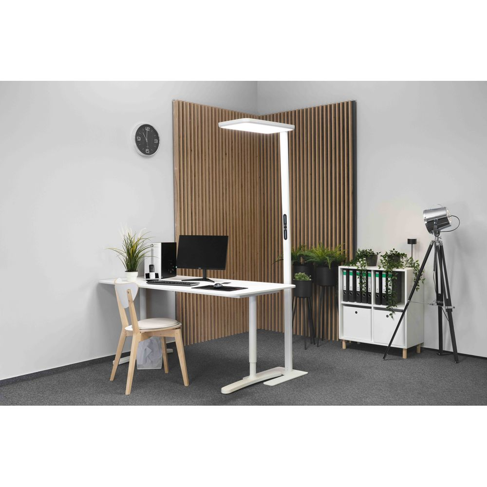 Moderne Büro-Ecke mit weißem Schreibtisch, großer Stehlampe, Holzstuhl und Lamellenwand im Hintergrund.