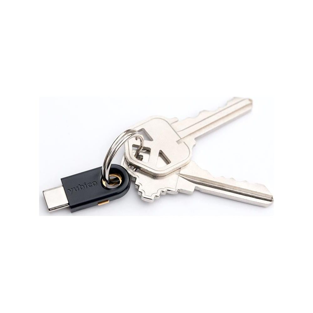 Ein schwarzer YubiKey-Sicherheitsschlüssel an einem Schlüsselring mit zwei silbernen Metallschlüsseln auf weißem Hintergrund.