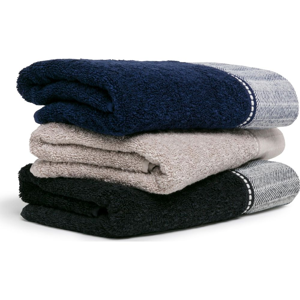 Ein ordentlicher Stapel aus drei gefalteten Handtüchern in Marineblau, Beige und Schwarz mit gemusterten Bordüren.