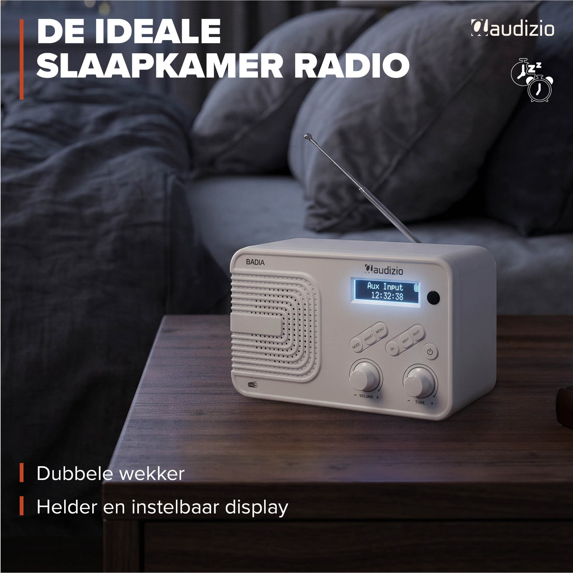Una radio blanca Audizio con antena se encuentra en una mesita de noche de madera oscura en un dormitorio.