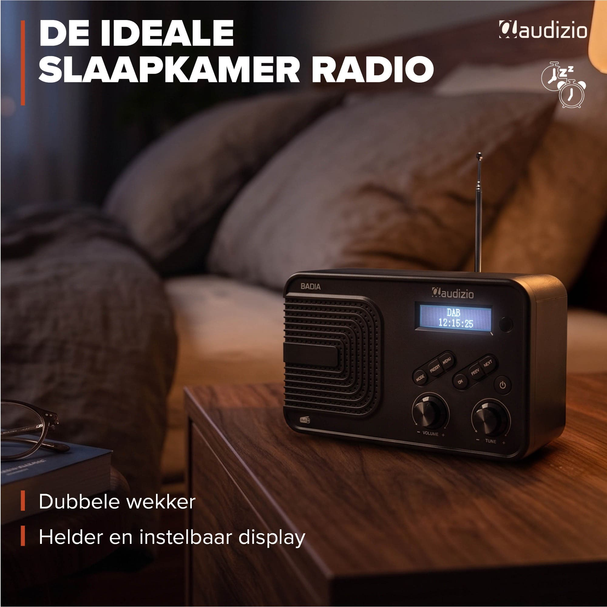 Una radio negra Audizio con pantalla digital se encuentra en una mesita de noche en un dormitorio.