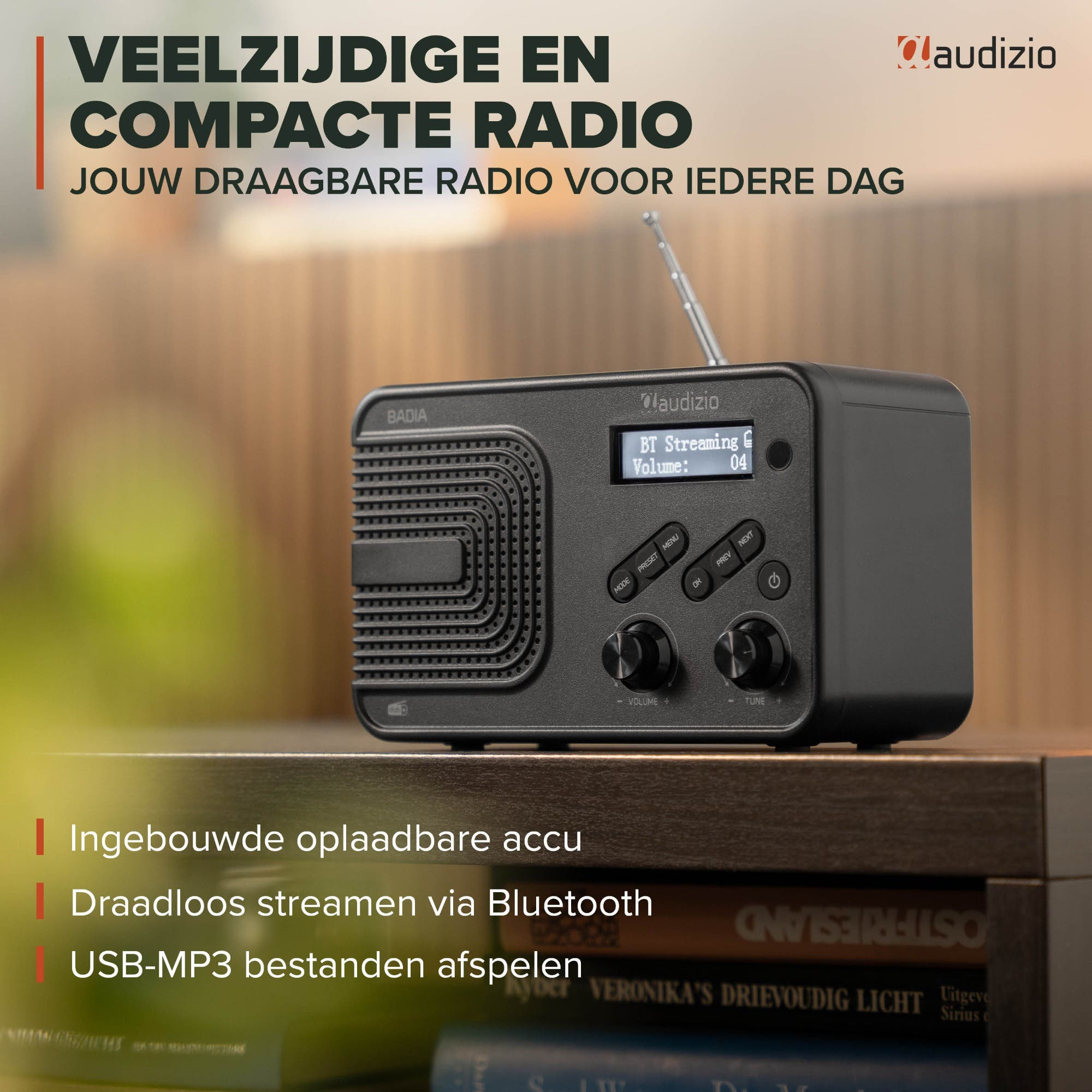 Una radio negra Audizio Badia descansa en un estante con texto y libros de fondo.