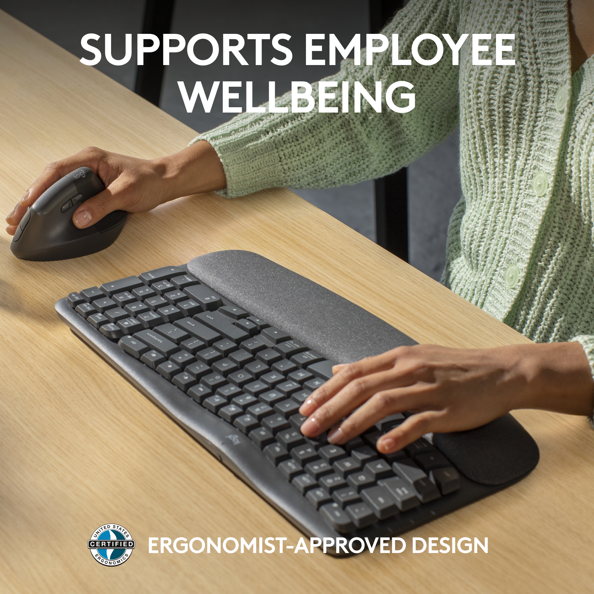 Eine Person benutzt eine ergonomische Vertikalmaus und eine geschwungene Tastatur mit Handgelenkstütze.