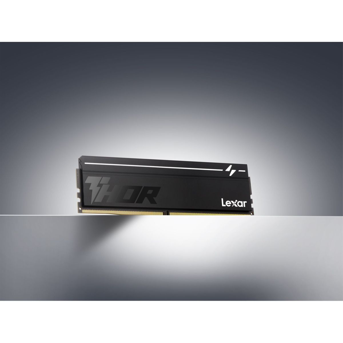 Un singolo modulo RAM Lexar Thor nero con scritta bianca e pin dorati su una superficie riflettente.