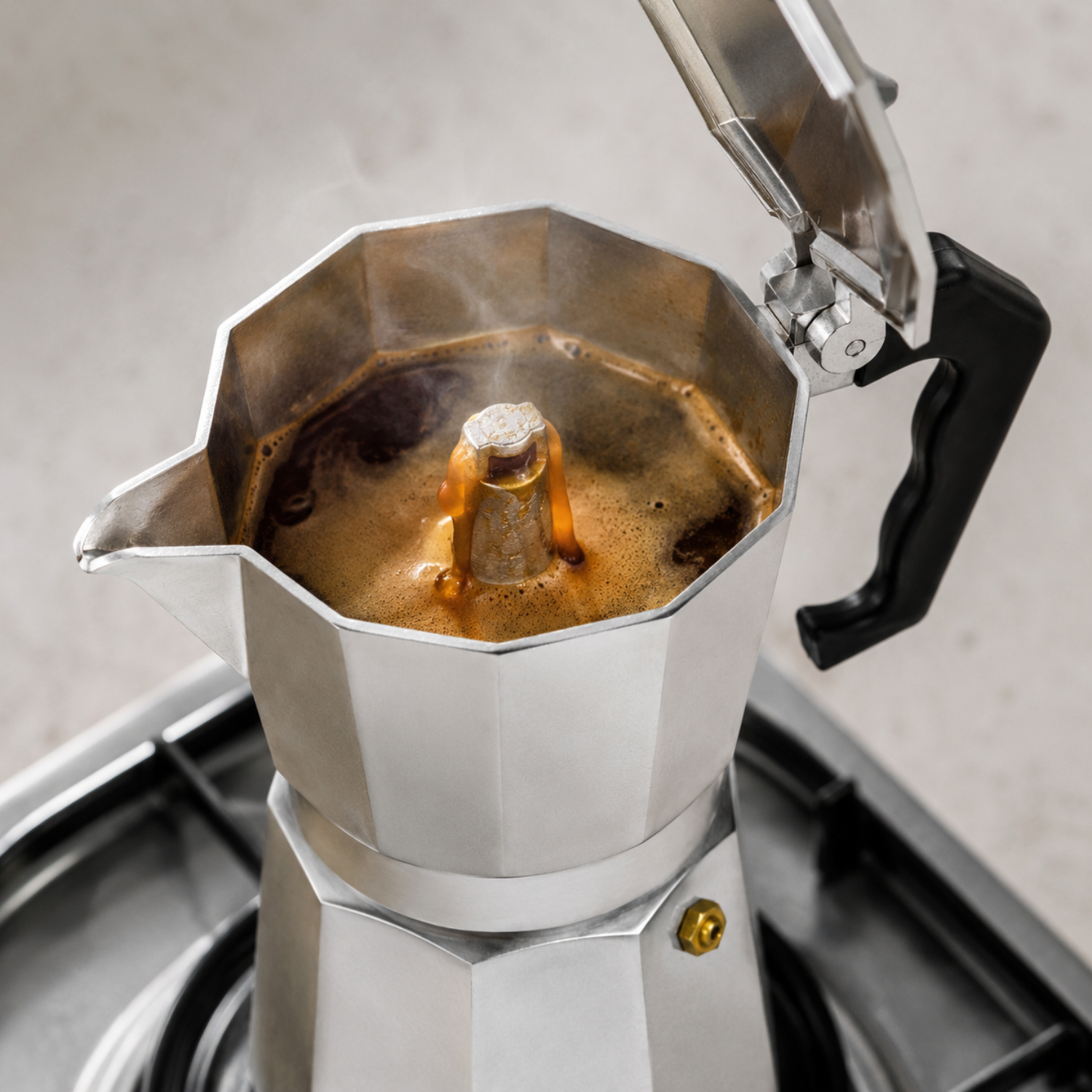 Una moka su un piano cottura con caffè fresco che sale.