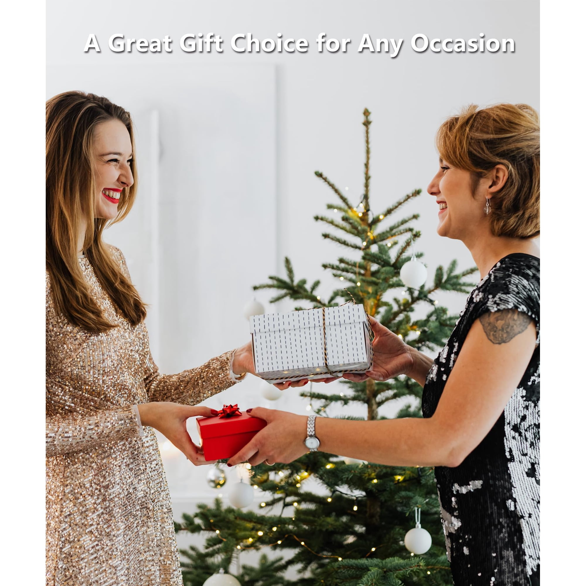 Zwei lächelnde Frauen tauschen vor einem geschmückten Weihnachtsbaum Geschenke aus.